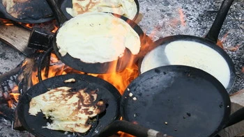 Billede af pandekager der bages over bål