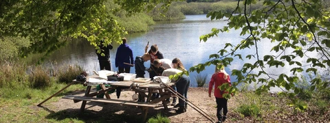 Billede af børn der studere hvad de har fanget i søen i Uhrehøj