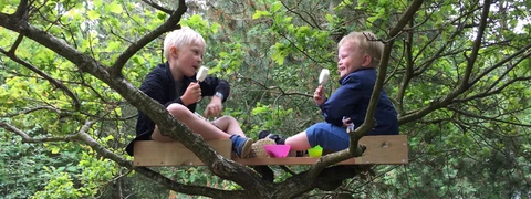 Billede af to børn der spiser is i deres træhytte