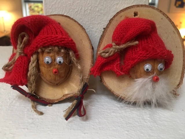 Billede af nisser lavet af en halv valnøddeskal på en skive af træ