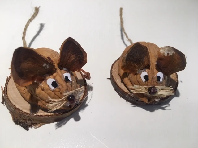 Små mus lavet af valnøddeskaller sat på en træskive