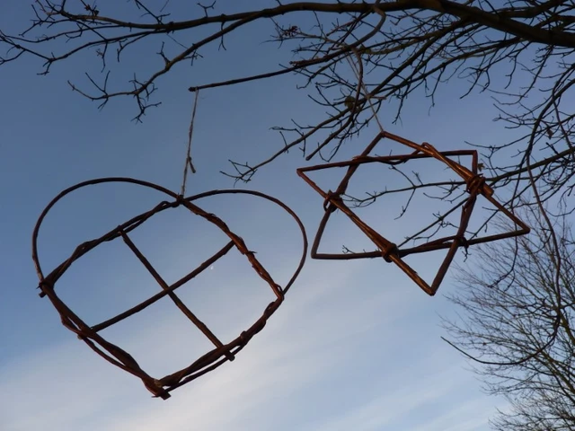 Billede af hjerte og stjerne flettet i pil, hænger i et træ