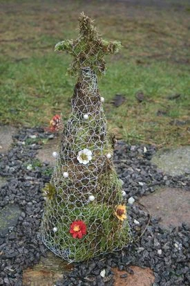 Billede af udendørs juletræ lavet i hønsenet pyntet med mos og blomster