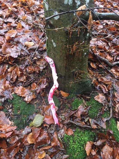 Nisse malet på en pind, der står ude i skoven