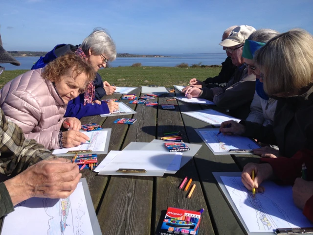 Billede af en gruppe mennesker, der sidder og maler