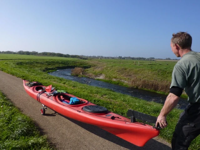 Billede af en mand, der er klar til, at sætte en kano i vandet