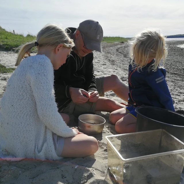 Familie på stranden der laver mad med primi deluxe