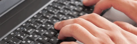 Billede af hænder på et tastatur