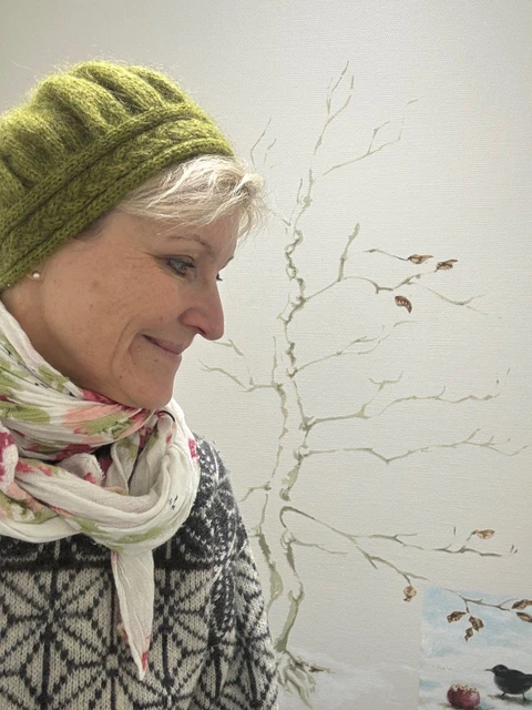 Karin ser på et motiv med en solsort